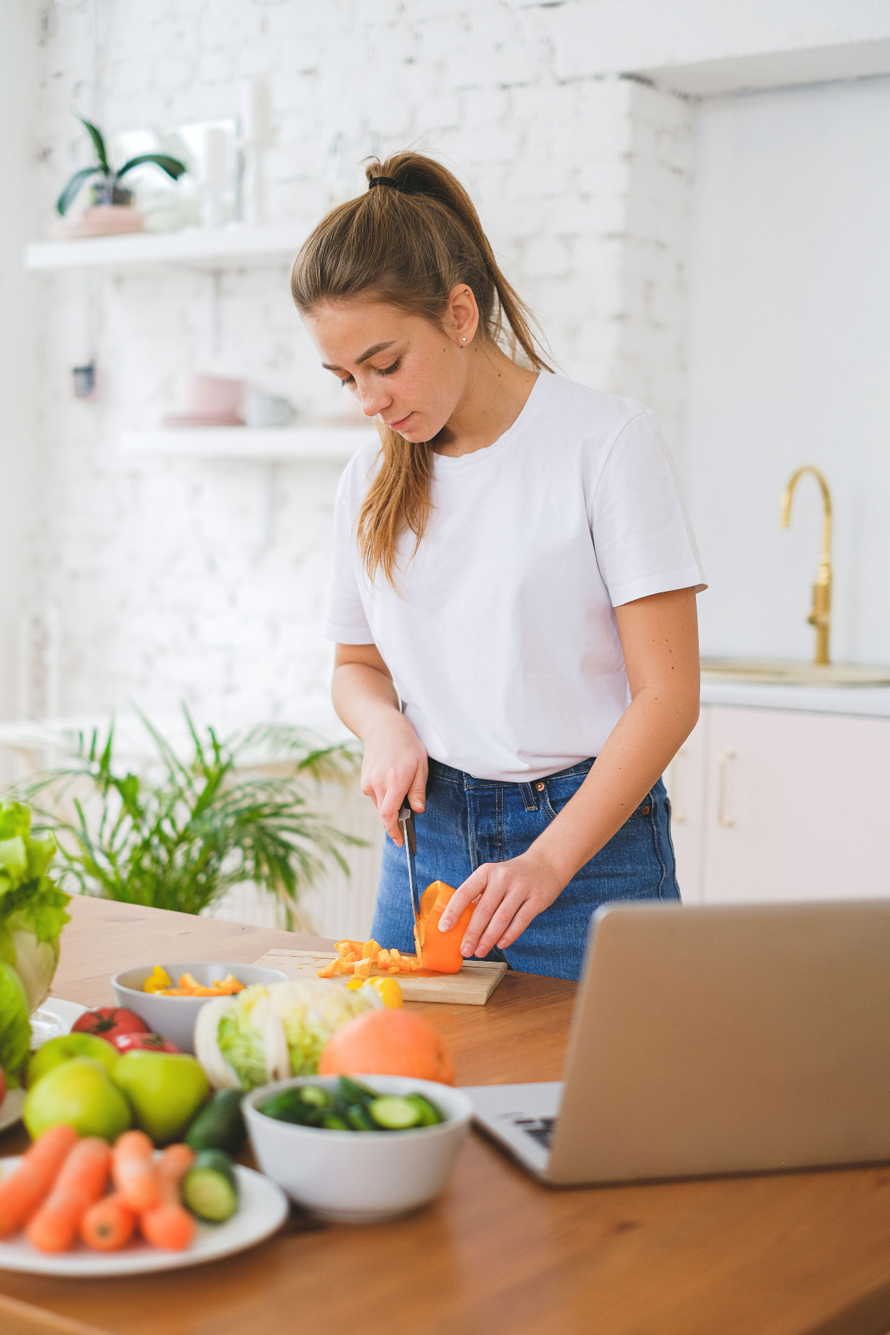 Femme préparant un repas simple et équilibré dans une cuisine lumineuse